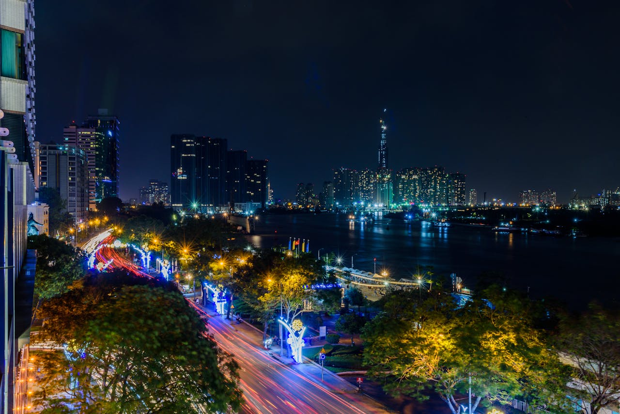 Contact Stunning nighttime view of Ho Chi Minh Citys skyline with illuminated roads and skyscrapers by the Saigon River.